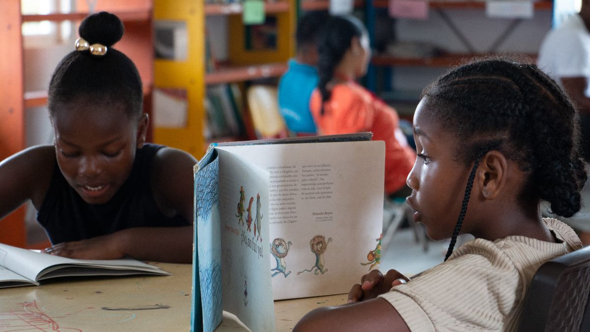 Niña leyendo en biblioteca